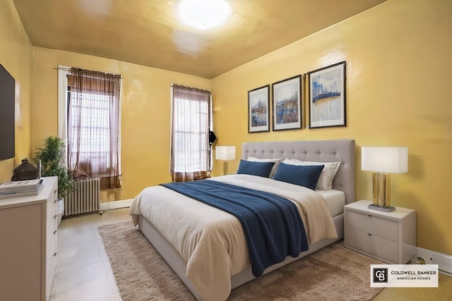 bedroom with light tile patterned flooring, radiator heating unit, and baseboards