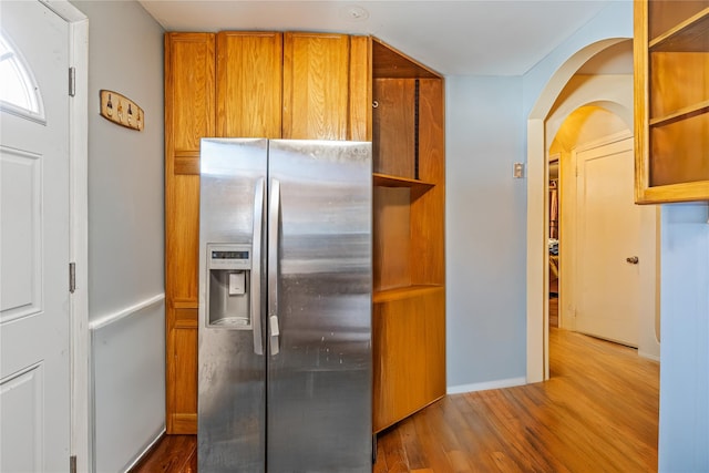 17718 Sayres Ave, Jamaica, NY 11433 - kitchen with stainless steel refrigerator with ice dispenser, open shelves, baseboards, brown cabinetry, and wood finished floors