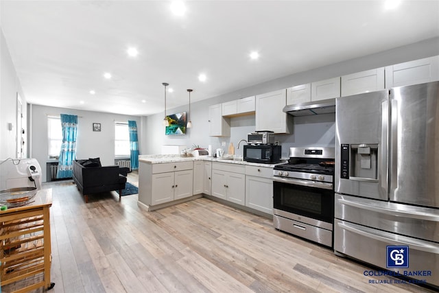 kitchen with light stone countertops, hanging light fixtures, stainless steel appliances, light hardwood / wood-style flooring, and white cabinets