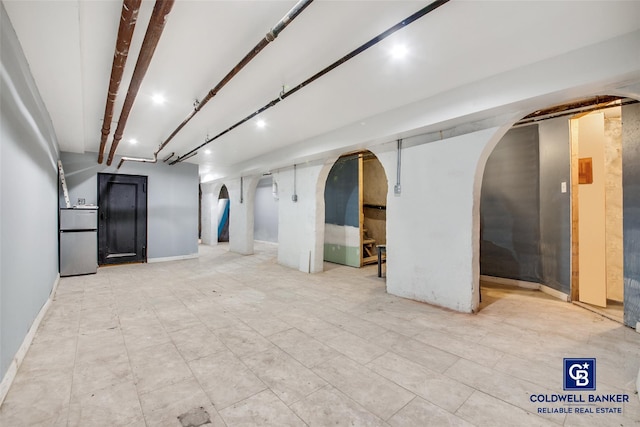 basement with stainless steel fridge