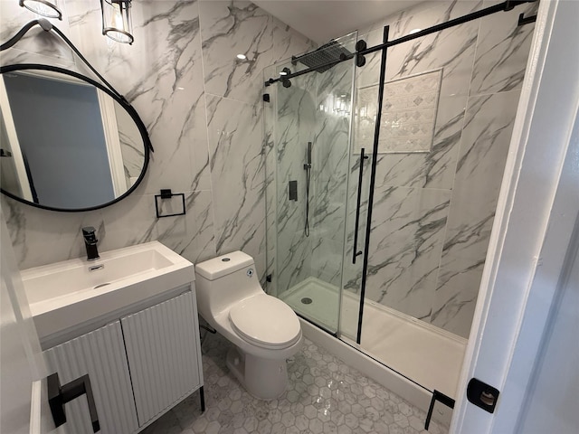 bathroom featuring tile patterned floors, toilet, vanity, a shower with shower door, and tile walls