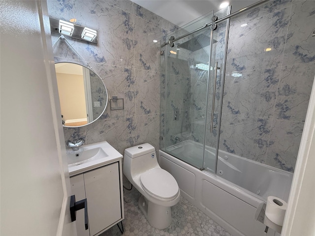 full bathroom featuring vanity, tile patterned floors, combined bath / shower with glass door, toilet, and tile walls