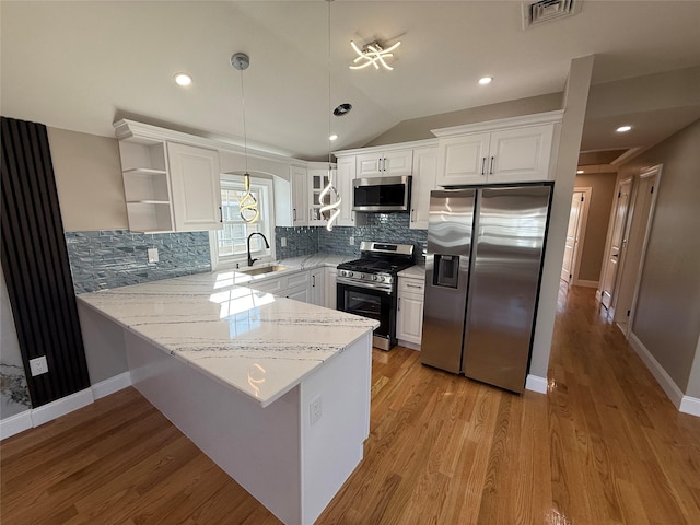 kitchen with white cabinets, sink, tasteful backsplash, kitchen peninsula, and stainless steel appliances