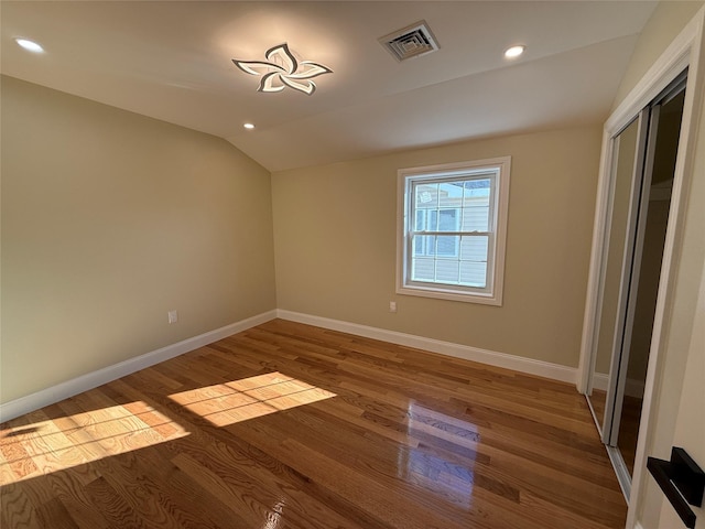 spare room featuring hardwood / wood-style floors and lofted ceiling