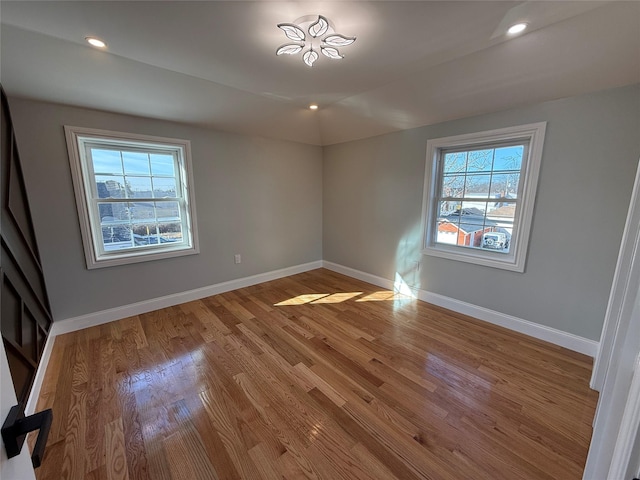 empty room featuring hardwood / wood-style floors and lofted ceiling