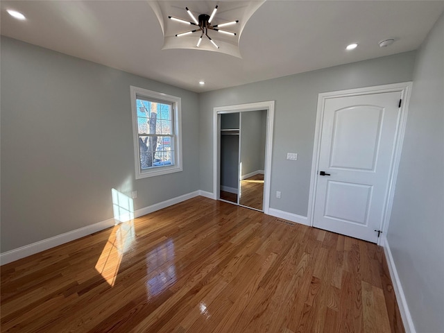 unfurnished bedroom featuring a closet and hardwood / wood-style flooring