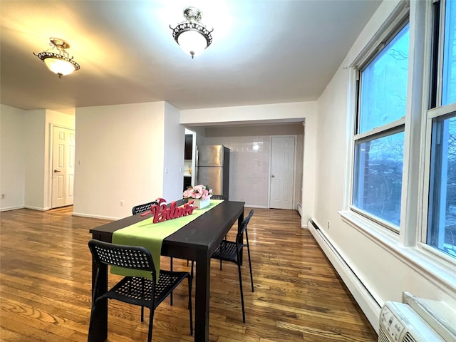 dining area featuring dark wood-type flooring and a baseboard radiator