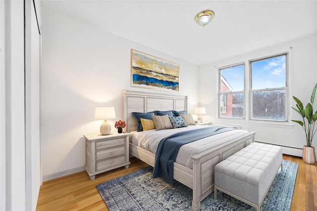 bedroom with baseboard heating and light wood-type flooring