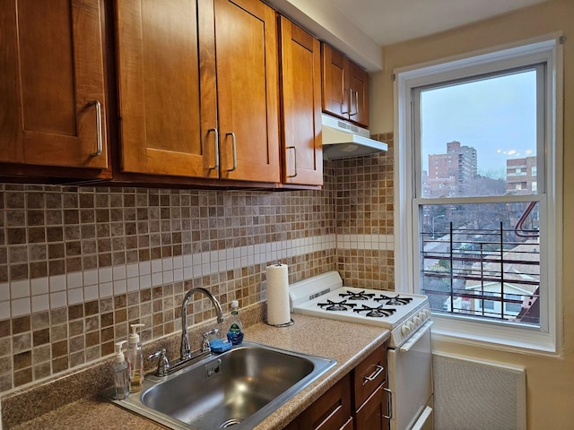 kitchen featuring white range oven, decorative backsplash, and sink