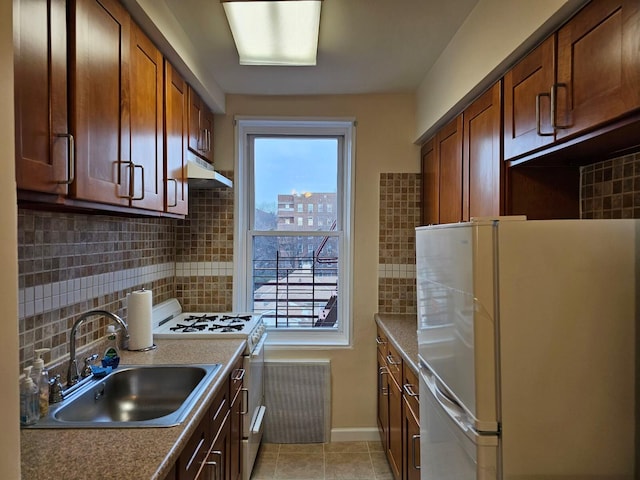 kitchen featuring decorative backsplash, white appliances, sink, and light tile patterned floors