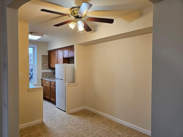 kitchen featuring tasteful backsplash, ceiling fan, and white fridge