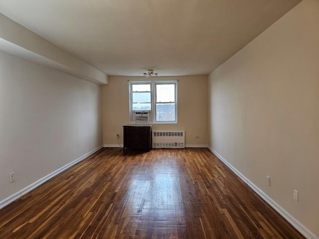 empty room with dark hardwood / wood-style floors, ceiling fan, and radiator heating unit