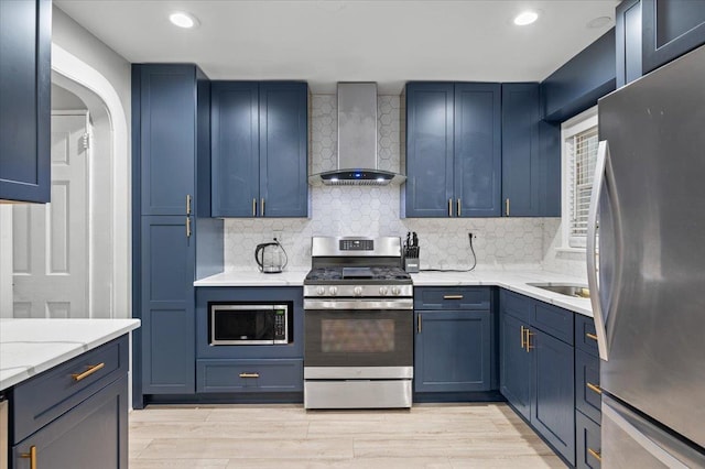 kitchen featuring wall chimney exhaust hood, appliances with stainless steel finishes, light hardwood / wood-style floors, and tasteful backsplash