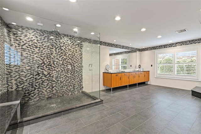 bathroom with tile patterned floors, vanity, and a shower with door