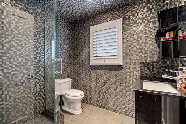 bathroom with tile patterned floors, vanity, toilet, and tile walls