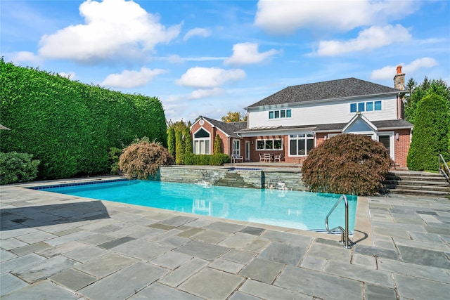 view of pool with a patio area and pool water feature