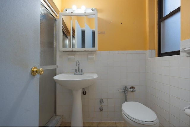 bathroom with tile walls and toilet