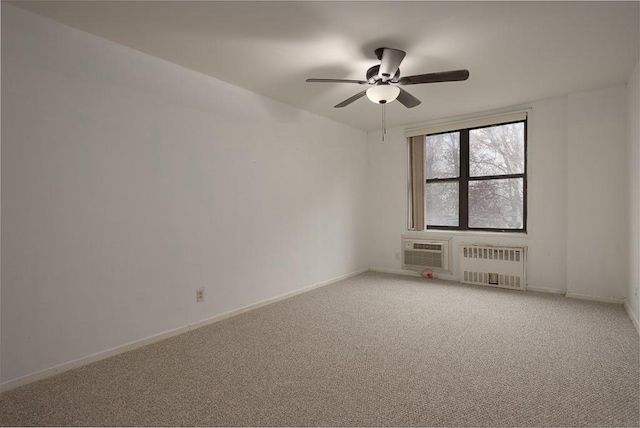 spare room featuring an AC wall unit, radiator, ceiling fan, and carpet flooring