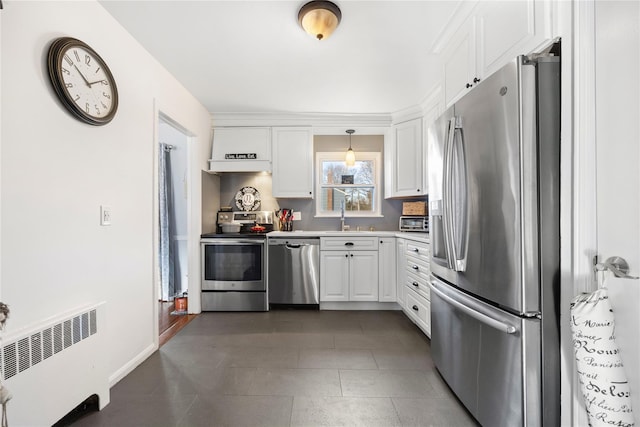 kitchen with decorative light fixtures, stainless steel appliances, radiator, white cabinets, and sink