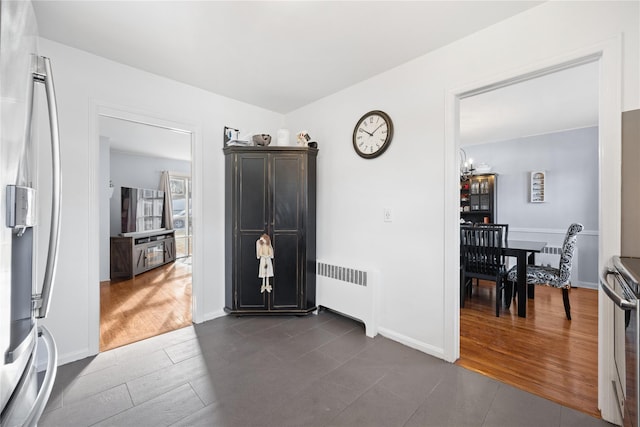 tiled entrance foyer featuring radiator heating unit