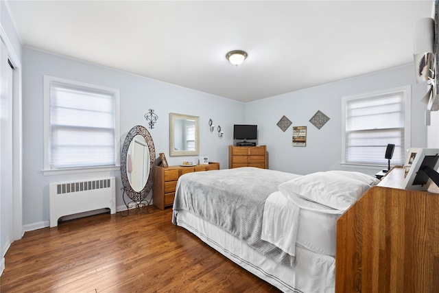 bedroom with radiator heating unit and dark hardwood / wood-style floors