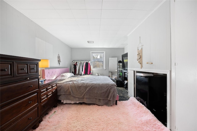 carpeted bedroom with wood walls