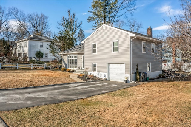 rear view of property with a garage and a yard