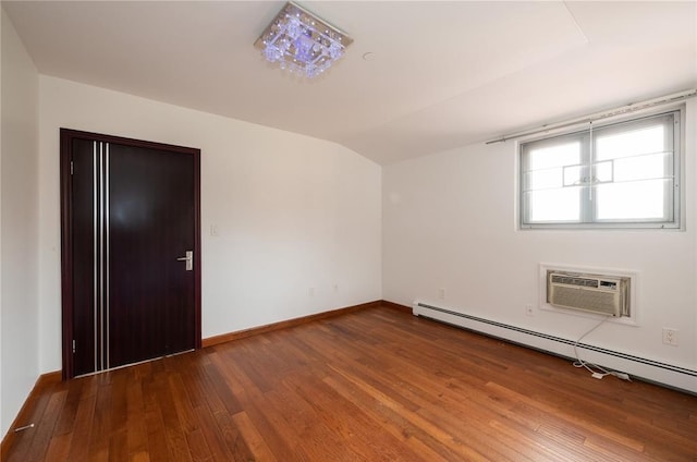 spare room with hardwood / wood-style floors, lofted ceiling, and a baseboard heating unit