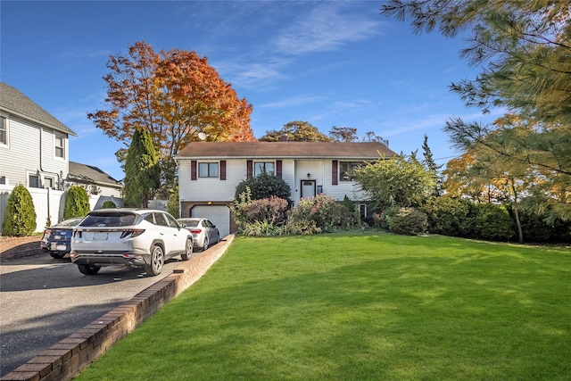 view of front of property featuring a front lawn and a garage