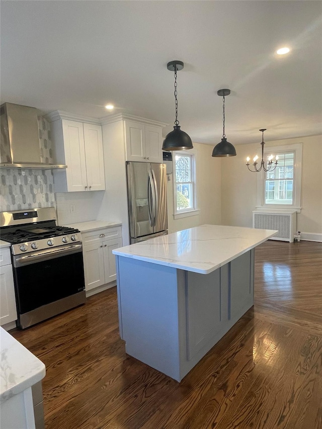 kitchen with radiator heating unit, a center island, stainless steel appliances, and white cabinetry