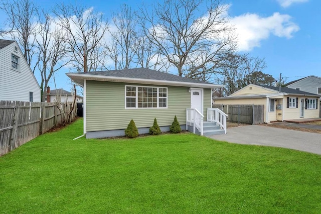 view of front of house with a front yard, a garage, and an outdoor structure