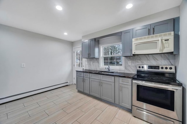 kitchen featuring sink, dark stone countertops, tasteful backsplash, stainless steel electric range oven, and a baseboard radiator