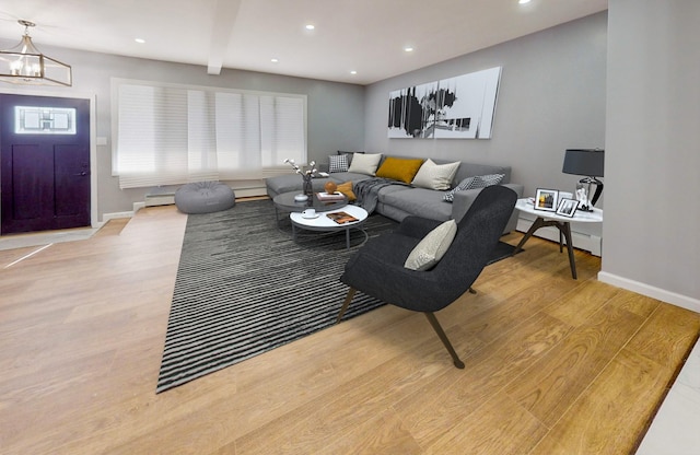 living room with beamed ceiling, light hardwood / wood-style flooring, and baseboard heating