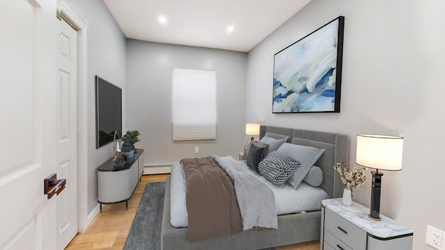 bedroom with light hardwood / wood-style flooring and a baseboard heating unit