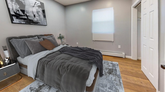 bedroom with hardwood / wood-style flooring and baseboard heating