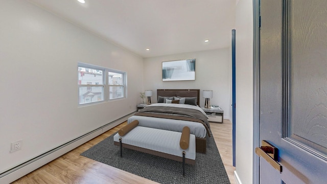 bedroom with hardwood / wood-style flooring and baseboard heating