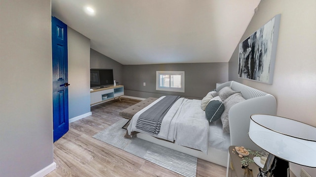 bedroom featuring light hardwood / wood-style flooring and vaulted ceiling