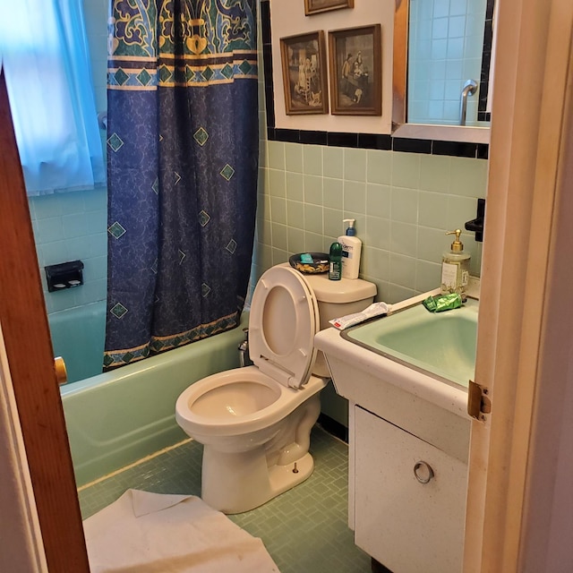 full bathroom featuring tile patterned flooring, shower / bath combination with curtain, toilet, vanity, and tile walls