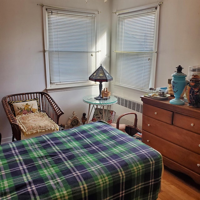 bedroom with radiator and light hardwood / wood-style flooring