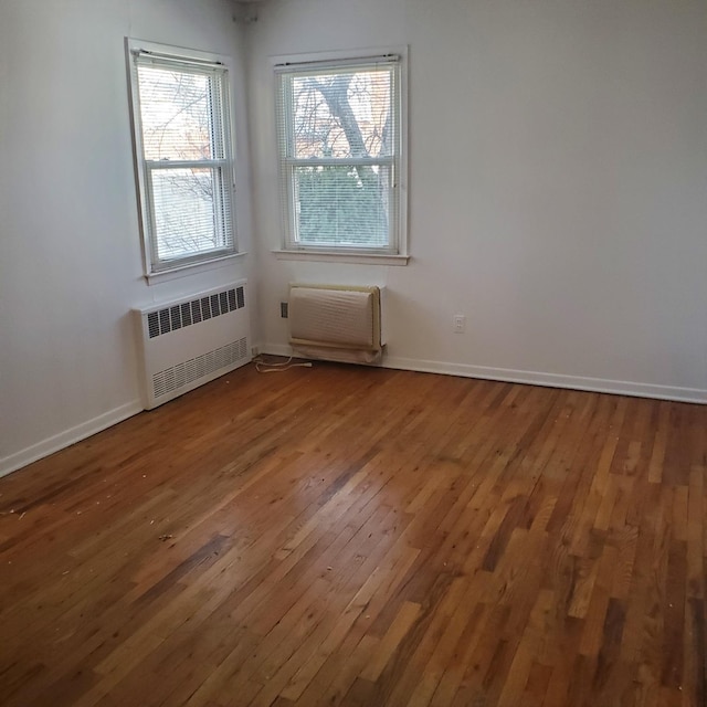 empty room featuring radiator heating unit and wood-type flooring