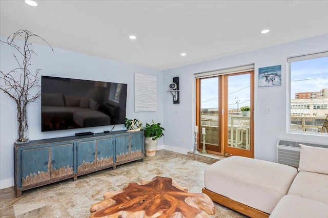 living room with a wall mounted AC and a healthy amount of sunlight