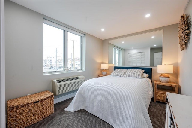 bedroom featuring dark colored carpet and a wall unit AC