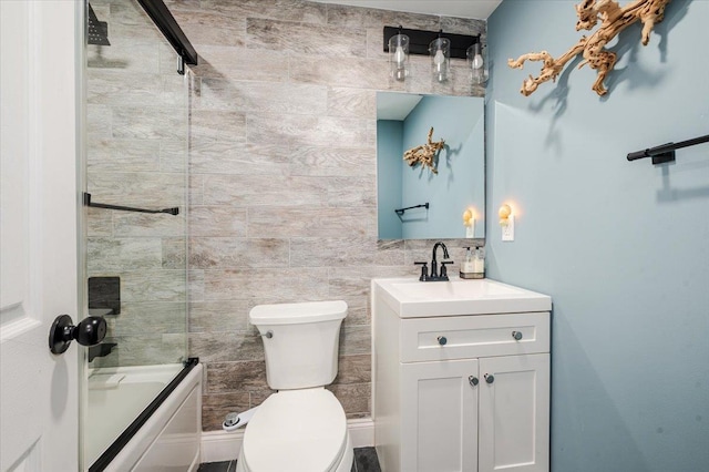 full bathroom featuring shower / bath combination with glass door, vanity, and toilet