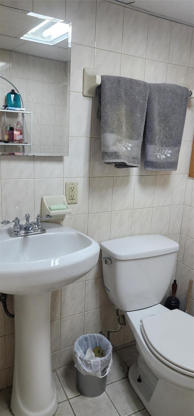 bathroom with tile walls, toilet, and tile patterned floors