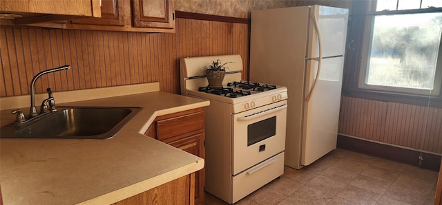 kitchen with sink, wooden walls, and gas range gas stove