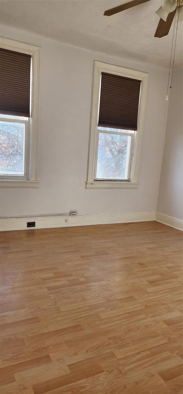 empty room featuring a textured ceiling and light wood-type flooring