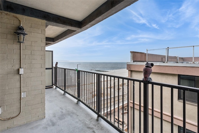 balcony featuring a view of the beach and a water view