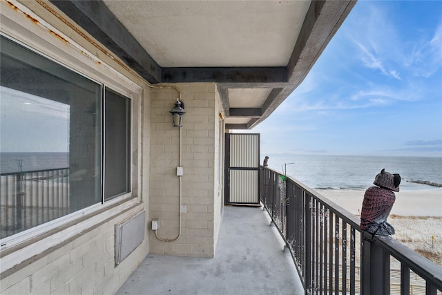 balcony featuring a water view and a beach view