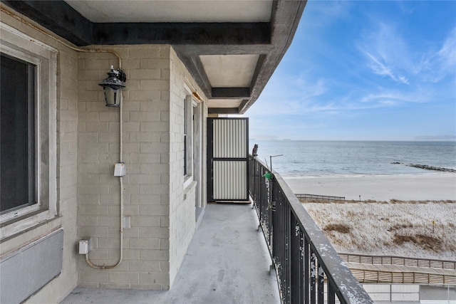 balcony featuring a water view and a beach view