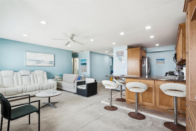 living room with ceiling fan and light colored carpet